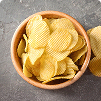 Top down view of a bowl of ridged potato chips